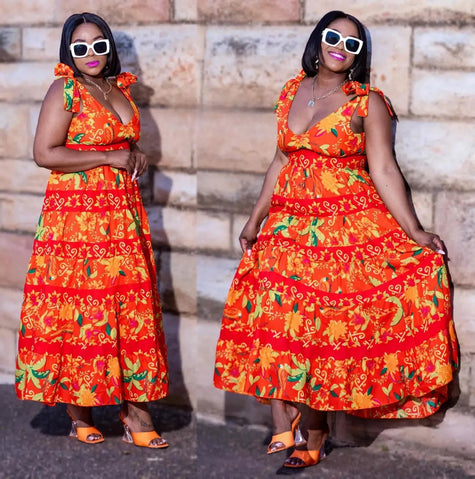 Orange floral maxi dress with V-neck, tied shoulder straps, and tiered skirt