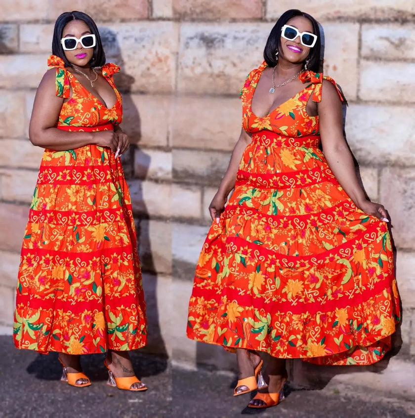 Orange floral maxi dress with V-neck, tied shoulder straps, and tiered skirt