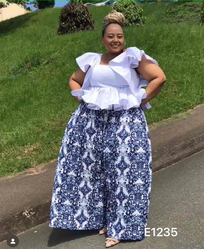 Blue-and-white ornate print wide-leg pants with white ruffle-sleeve top, full body