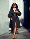 Black puff-sleeve double-breasted trench coat with wide belt and flap pockets