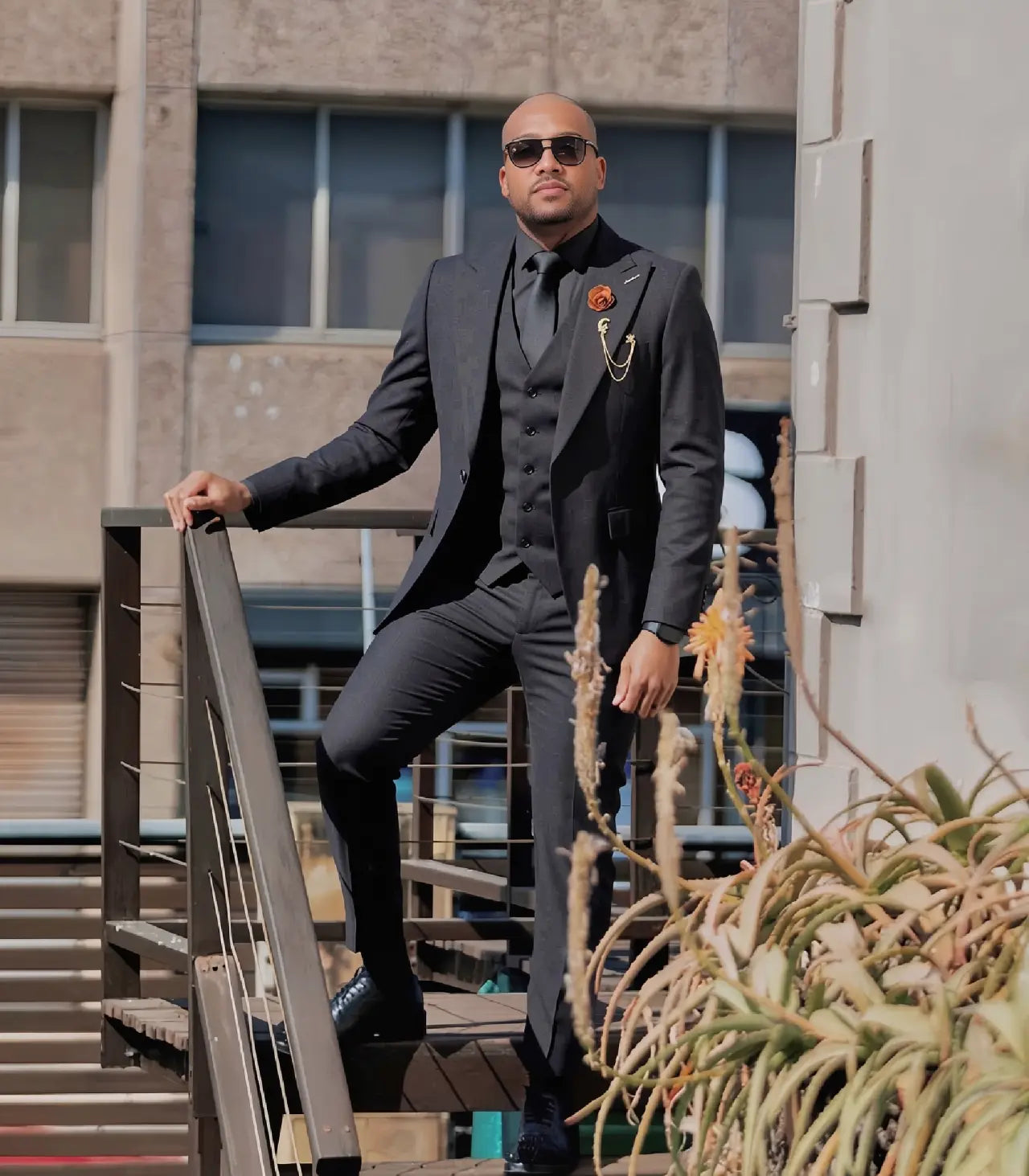 Men's black three-piece suit with shawl lapels, vest, and matching trousers