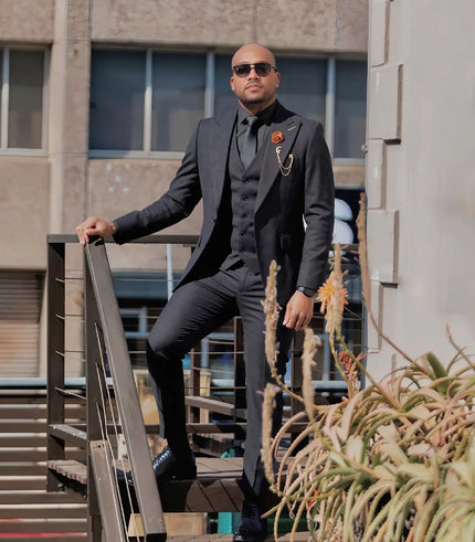 Men's black three-piece suit with shawl lapels, vest, and matching trousers