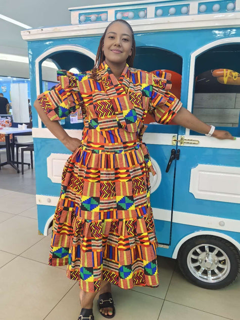 Colorful African print wrap dress with puff sleeves, tie belt, and tiered skirt