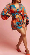 Printed mini dress with puff sleeves, wrap V-neck, teal and orange floral pattern, tie belt.