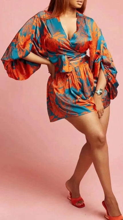 Printed mini dress with puff sleeves, wrap V-neck, teal and orange floral pattern, tie belt.