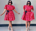 Red floral mini dress with puff sleeves, black waist belt, and flared skirt