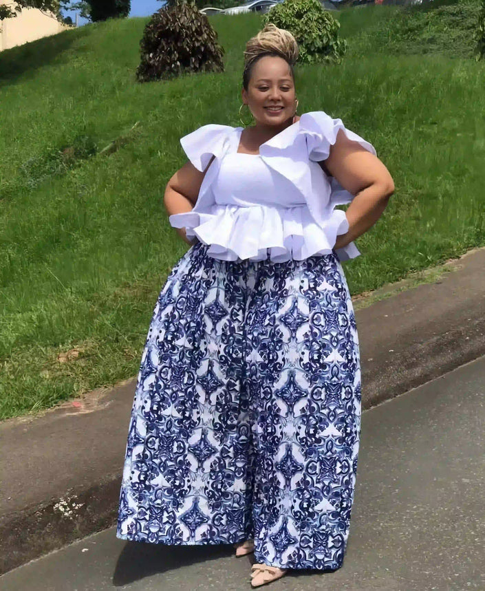 White ruffle-sleeve top with blue ornate print wide-leg pants, front view