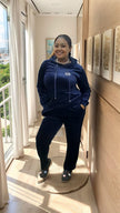 Navy hooded zip tracksuit set with drawstring and small chest emblem; matching joggers