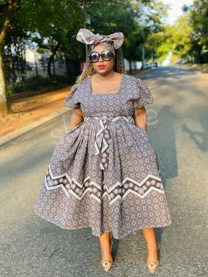 Geometric A-line midi dress with puff sleeves, square neckline, and bow tie waist