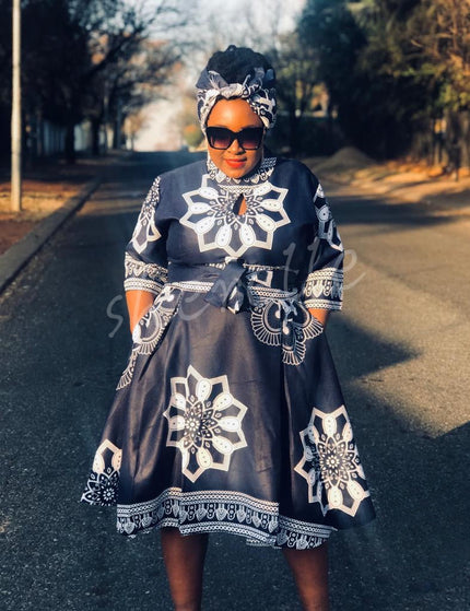 Black African print dress with matching headwrap, long sleeves and knee-length hem