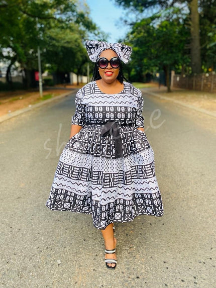 Geometric black-and-white midi dress with round neck, cap sleeves, gathered waist