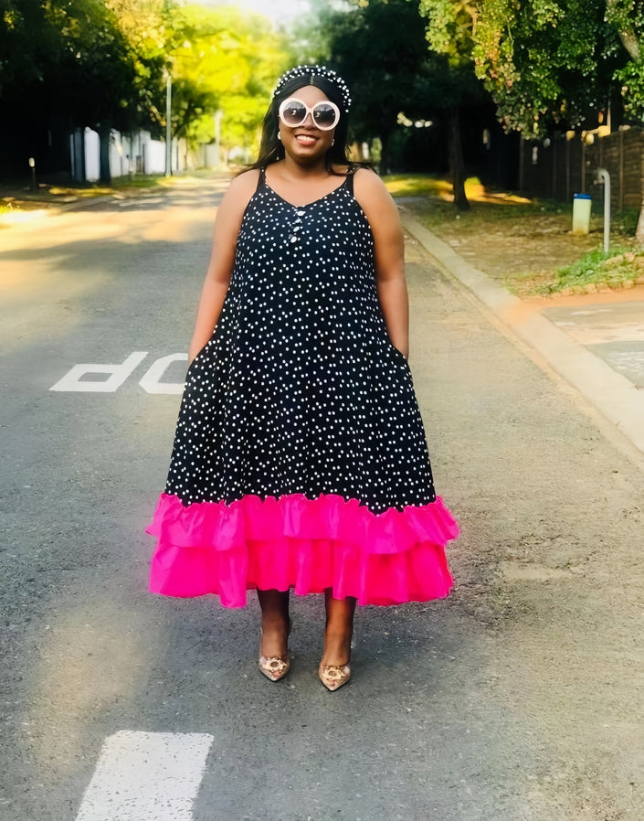 Polka dot maxi dress with spaghetti straps, black with white dots, pink ruffle hem.