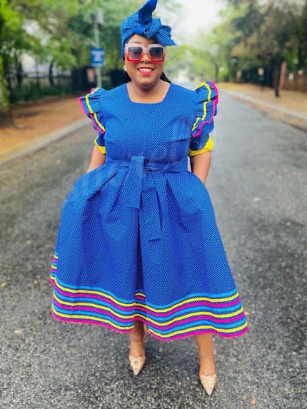 Blue polka dot midi dress with ruffle sleeves and rainbow striped hem