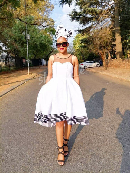 White sleeveless A-line midi dress with striped hem and flared skirt