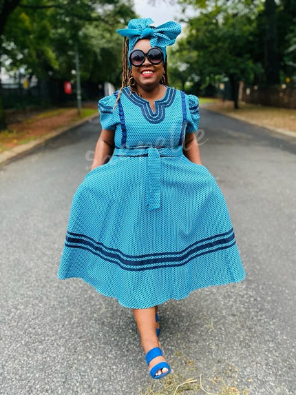 Turquoise puff-sleeve heritage dress with round neckline and patterned trim