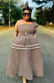 Geometric tiered dress with off-shoulder neckline, brown patterned fabric, belted waist