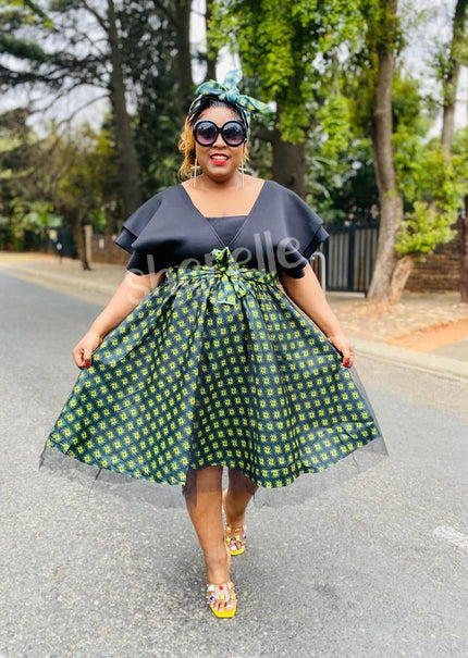 V-neck geometric skirt dress with bow waist, dark bodice and green patterned skirt
