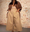 Tan high-waist wide-leg pleated trousers with belt loops