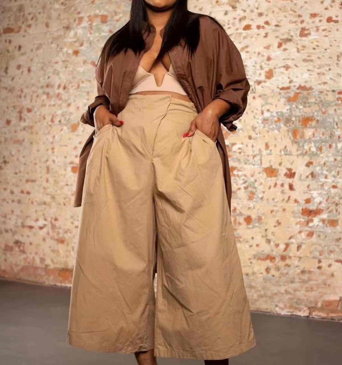 Tan high-waist wide-leg pleated trousers with belt loops