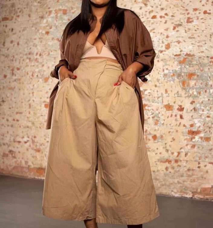 Tan high-waist wide-leg pleated trousers with belt loops