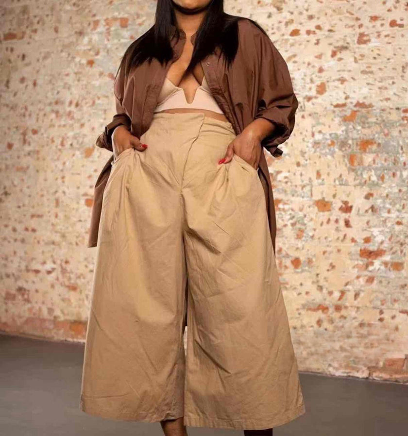 Tan high-waist wide-leg pleated trousers with belt loops