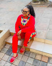 Red twin set outfit with African print neckline and matching pants, long sleeves.