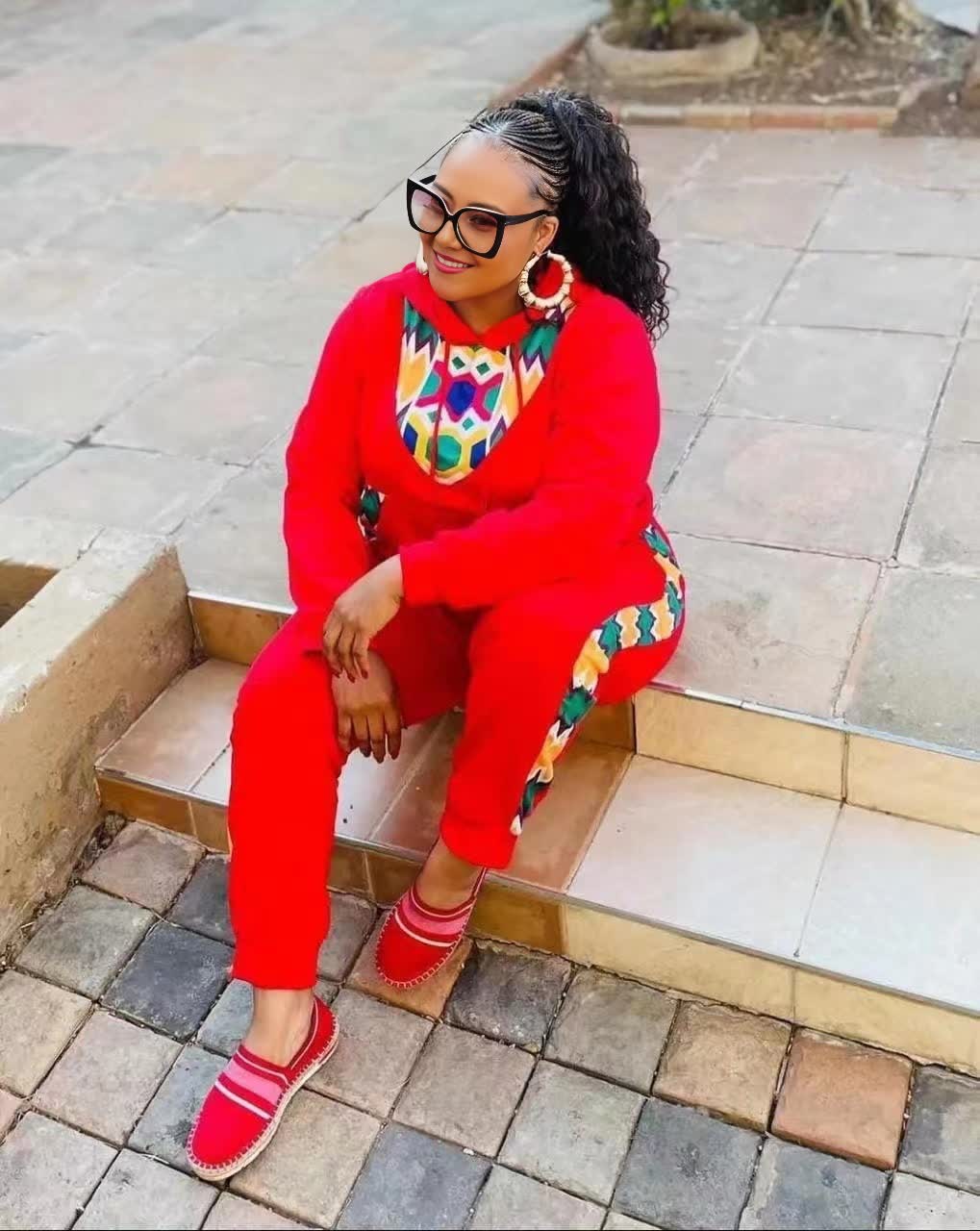 Red twin set outfit with African print neckline and matching pants, long sleeves.