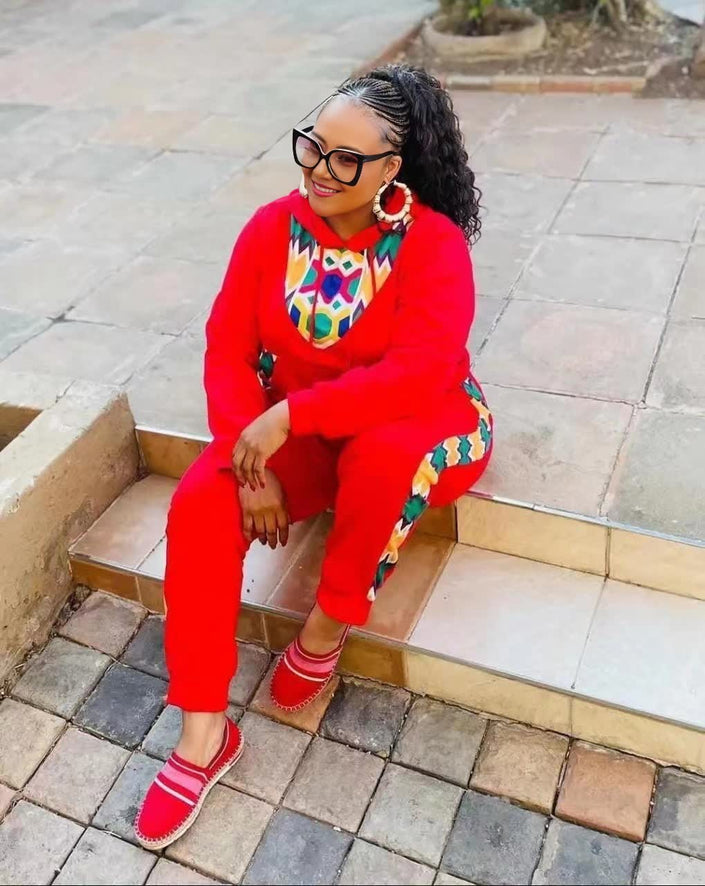 Red twin set outfit with African print neckline and matching pants, long sleeves.