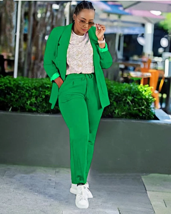 Green blazer and matching trouser set with single-breast jacket and tapered pants.