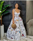 White maxi dress with thin straps, scoop neckline, and abstract animal print tiered skirt.