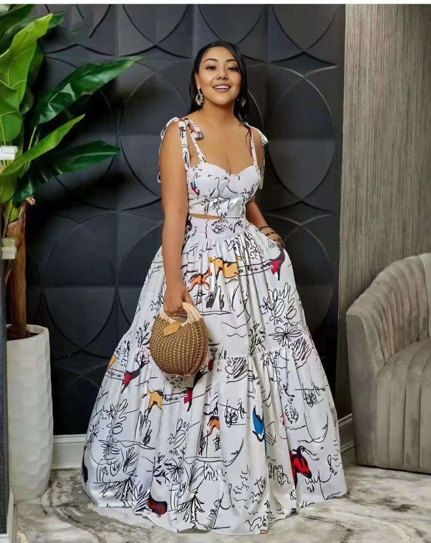 White maxi dress with thin straps, scoop neckline, and abstract animal print tiered skirt.