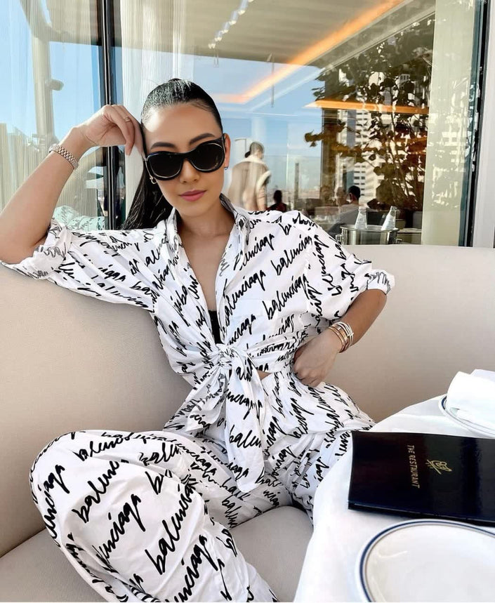 Printed two-piece outfit: white collared tied top and black-script wide-leg pants