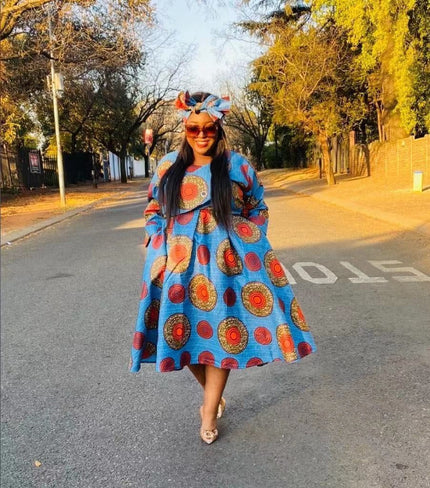 Sky-blue African print midi dress with long sleeves and flared skirt, red circular motifs