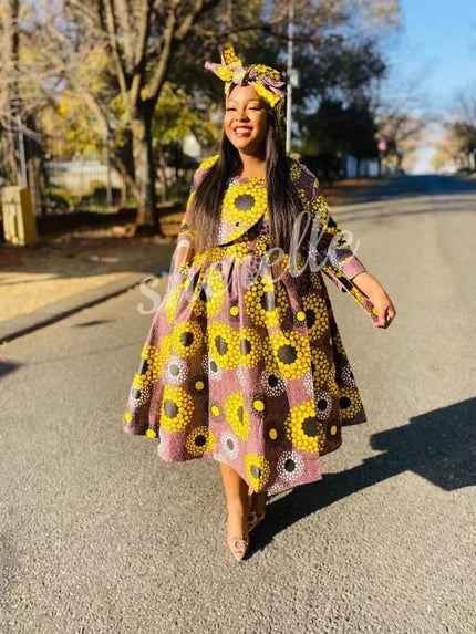 Purple African print midi dress with long sleeves and flared skirt, yellow and dark dot motifs