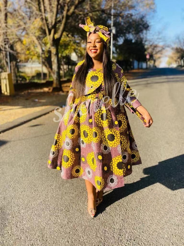 Purple African print midi dress with long sleeves and flared skirt, yellow and dark dot motifs