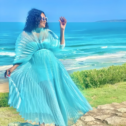 Turquoise pleated maxi dress with cinched waist and flowing, flared skirt