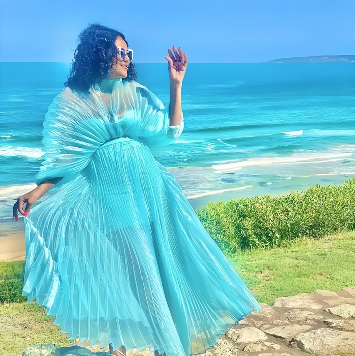 Turquoise pleated maxi dress with cinched waist and flowing, flared skirt