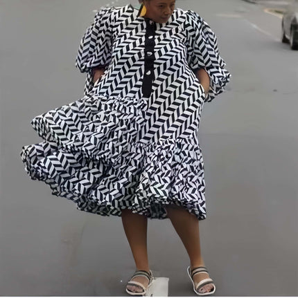Plus size geometric midi dress with black-and-white puff sleeves and tiered ruffles