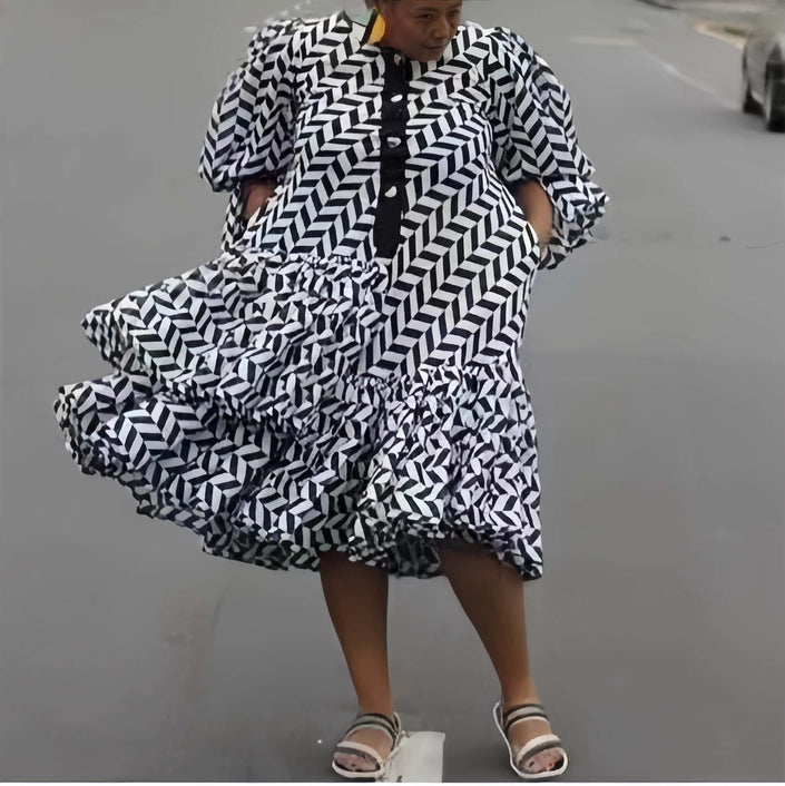 Plus size geometric midi dress with black-and-white puff sleeves and tiered ruffles