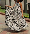 Black and white halter maxi dress with flowing floral print, sleeveless halter neckline