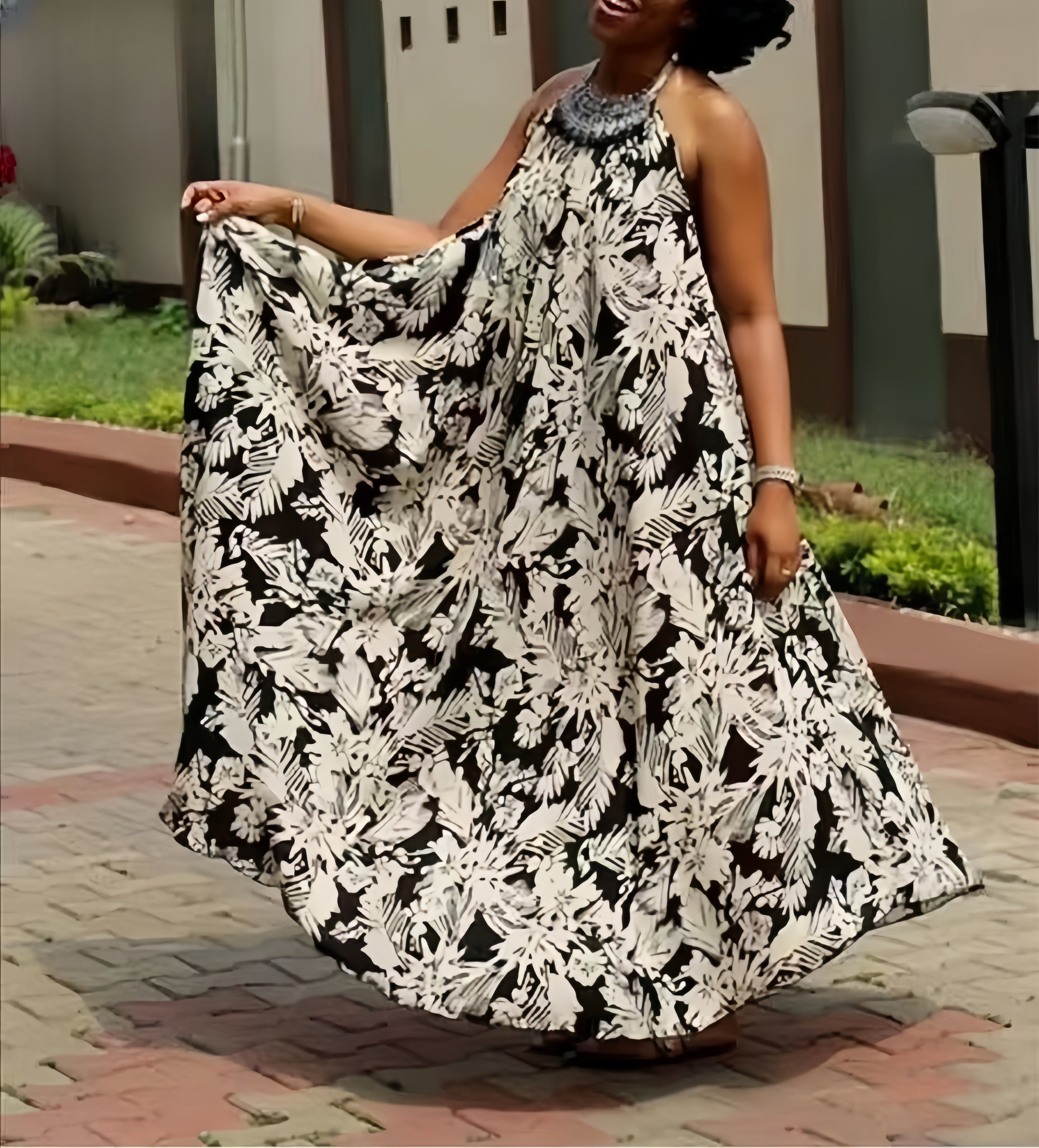 Black and white halter maxi dress with flowing floral print, sleeveless halter neckline