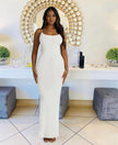 White sleeveless maxi dress with straight neckline, fitted column silhouette.