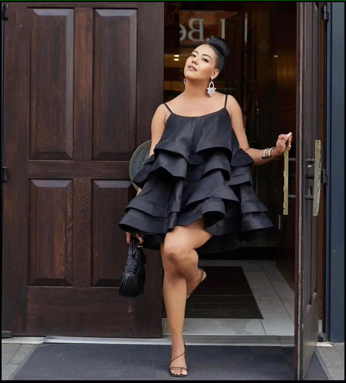 Black tiered ruffle mini dress with adjustable spaghetti straps and layered skirt.