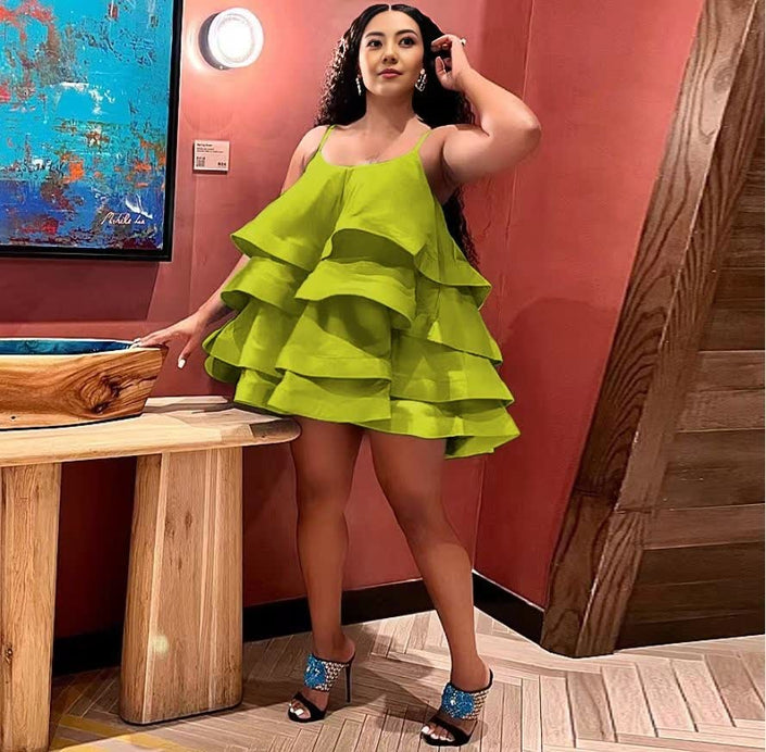 Green tiered ruffle mini dress with adjustable spaghetti straps and layered skirt.