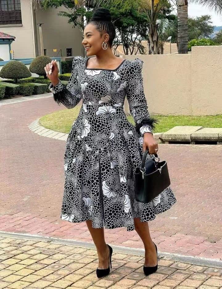 Black-and-white patterned midi dress with puff sleeves, square neckline, gathered skirt.