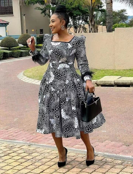 Black-and-white patterned midi dress with puff sleeves, square neckline, gathered skirt.