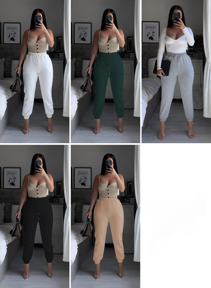 White high-waist jogger pants with stretch waistband and tapered ankle cuffs