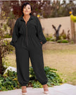 Black collared zip-front jumpsuit with long sleeves, gathered waist, cuffed tapered legs.