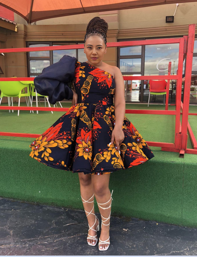 One-shoulder puff-sleeve dress, bold red/navy floral print, flared skirt