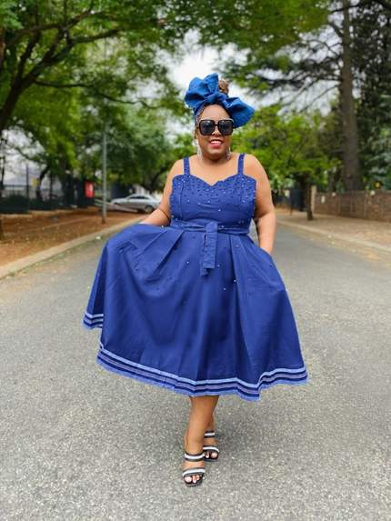 Blue flared dress with rhinestone bodice, sleeveless straps, striped hem